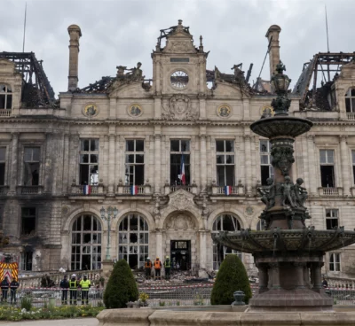 Vue de l’hôtel de ville de Limoges au lendemain de l’incendie, avec sa toiture détruite, sa charpente calcinée et des pompiers devant le bâtiment