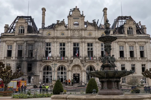 Vue de l’hôtel de ville de Limoges au lendemain de l’incendie, avec sa toiture détruite, sa charpente calcinée et des pompiers devant le bâtiment