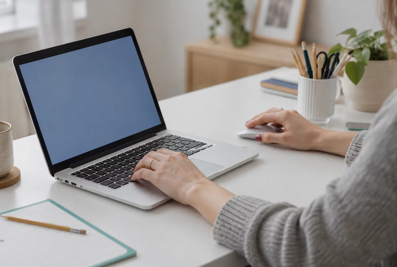 Un électeur utilise un ordinateur portable et une souris sur un bureau domestique, pour accéder à une plateforme de vote en ligne.
