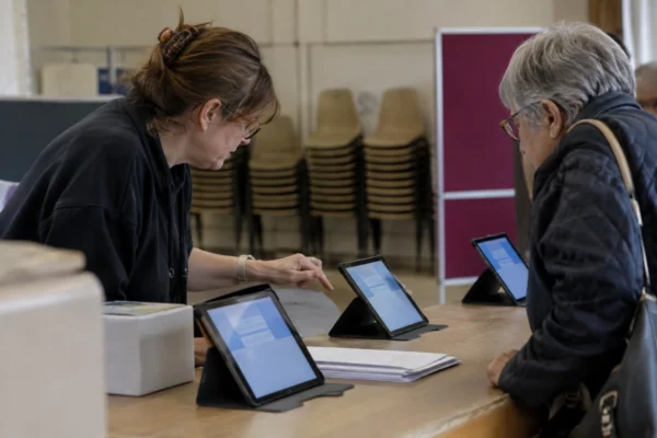 Des tablettes sont disposées sur un comptoir dans une salle polyvalente aménagée pour accompagner le vote en ligne.