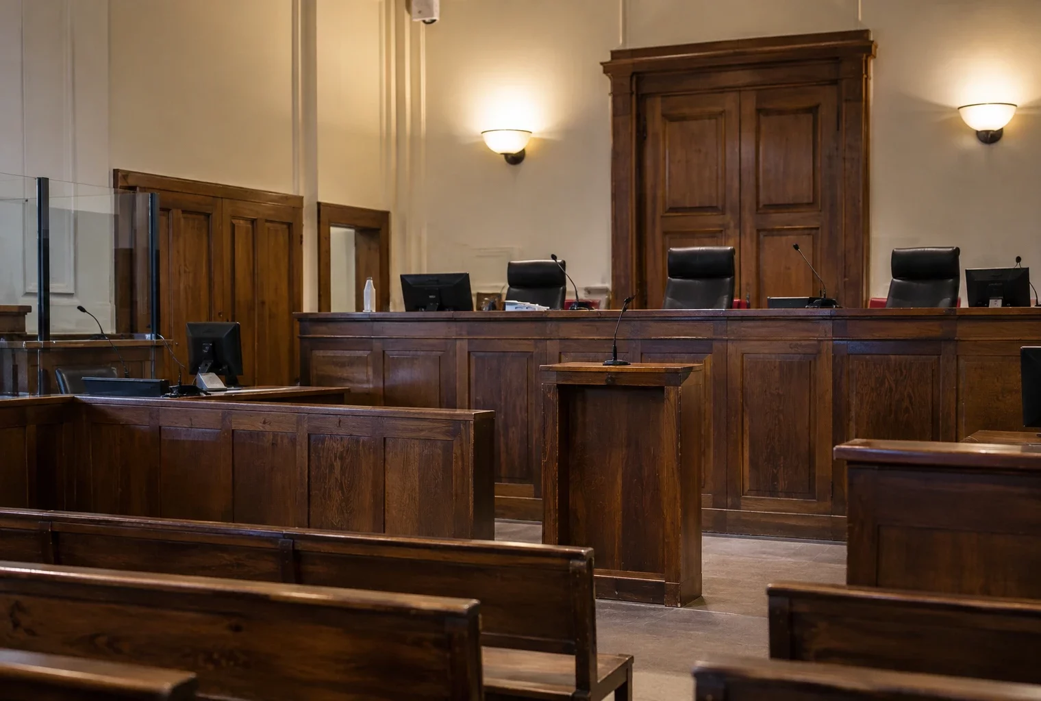 Salle d’audience vide avec bancs, pupitre des magistrats et sièges destinés au public dans un tribunal.