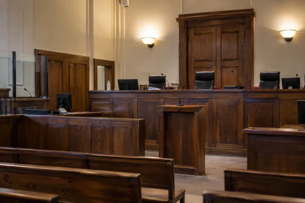 Salle d’audience vide avec bancs, pupitre des magistrats et sièges destinés au public dans un tribunal.