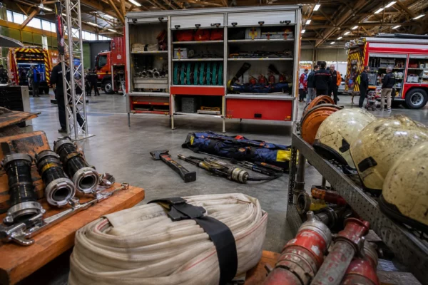 Salon des pompiers dans un hall à La Roche-sur-Foron, avec matériel de secours, stands et véhicules en arrière-plan.
