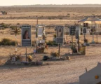 Le site commémoratif du festival Tribe of Nova, avec des objets déposés au sol et un paysage désertique en arrière-plan.