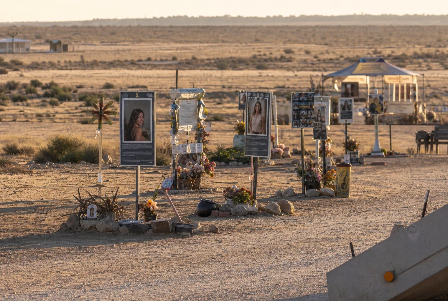 Le site commémoratif du festival Tribe of Nova, avec des objets déposés au sol et un paysage désertique en arrière-plan.