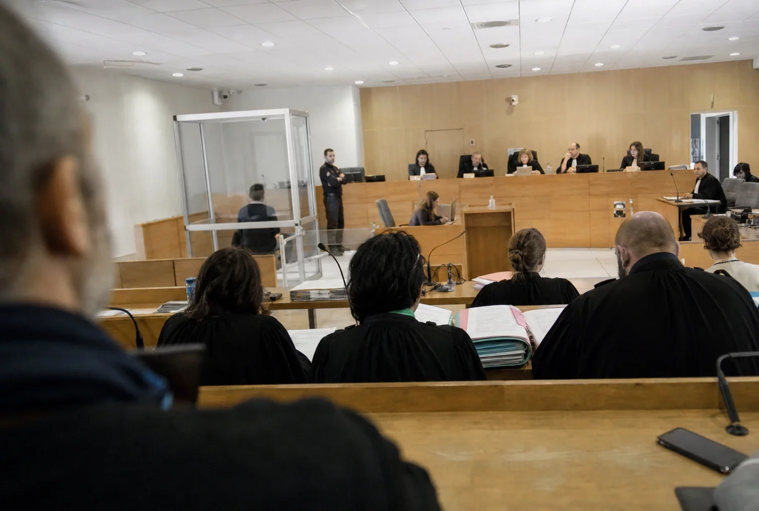 Salle d’audience du tribunal correctionnel de Montpellier avec bancs, tables et estrade avant l’ouverture du procès.