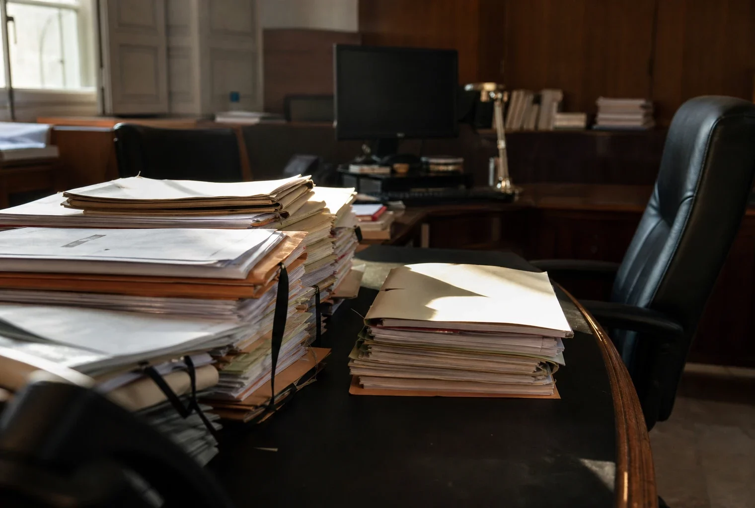 Bureau judiciaire avec dossiers empilés dans le tribunal judiciaire de Paris