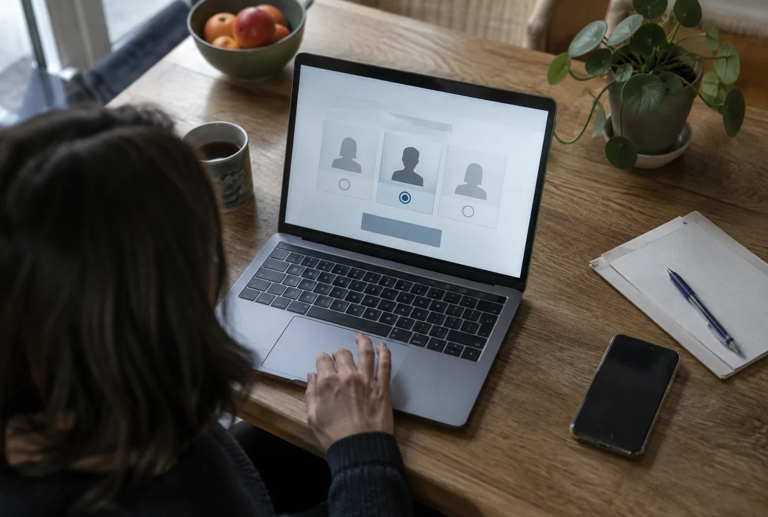Un ordinateur portable ouvert sur une interface de vote en ligne, tandis qu’une main repose sur le pavé tactile.